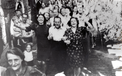879131 Afbeelding van een grote groep uitbundige feestvierders op een bevrijdingsfeest in de Achterstraat in Wijk C te ...